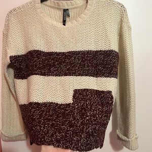 beige/cream sweater with dark purple stripes. Sleeves cuffed.
